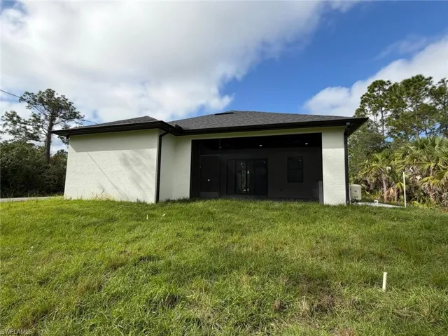 View of property exterior with a yard and stucco siding