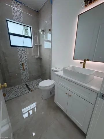 Full bathroom featuring vanity and a shower stall
