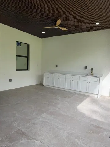 Unfurnished room with ceiling fan and concrete flooring