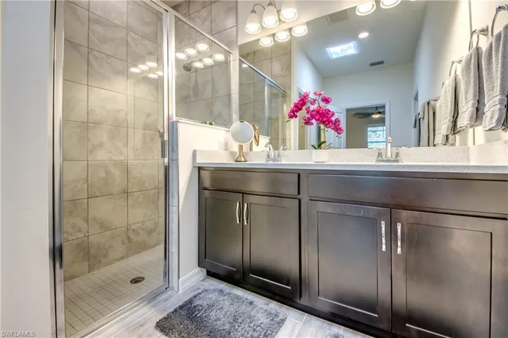 Identical quartz counters and dark wood cabinetry are throughout the home. Skylight was installed in both bathrooms to provide light without having to flip a switch. Nightlight on skylight is additional feature.