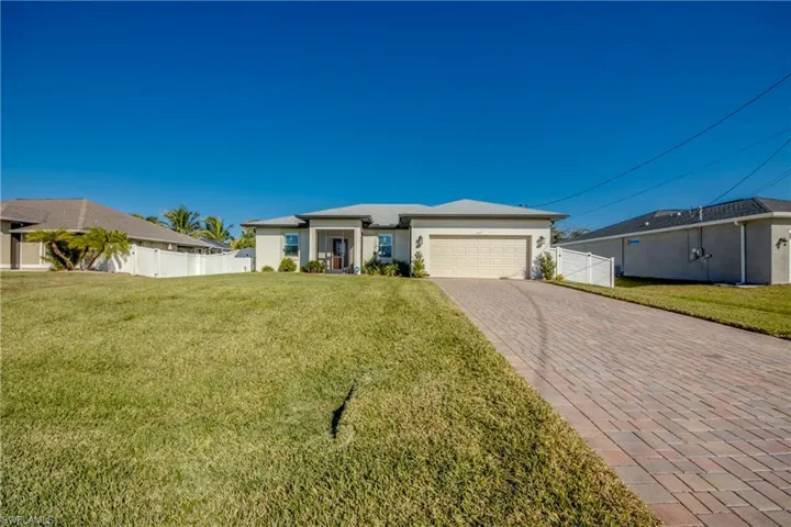 Lush grass surrounds this beautiful home. Paver driveway continues up to front screened porch. Backyard is fully fenced and there is a 5' gate on both sides of yard.