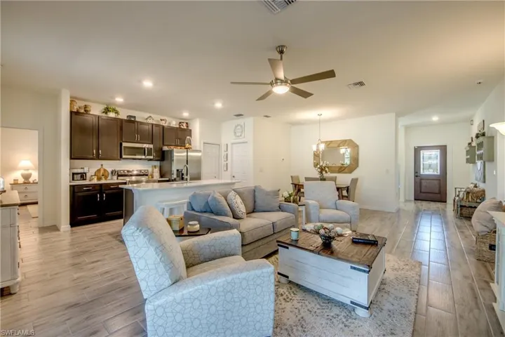 Great Room in center of home has open layout and easy access to every room in the house. Plank tile flooring is throughout the home. The front door was replaced with one that has a glass panel to brighten up the entry.