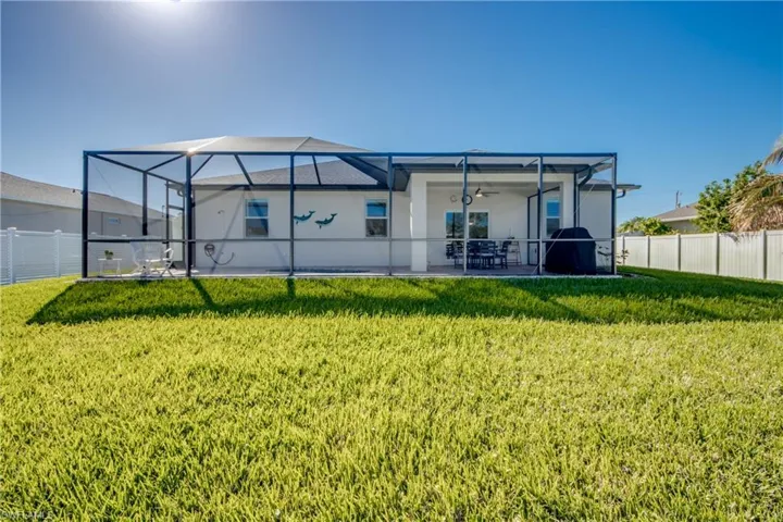 Lush green grass in backyard is due to upgraded sod and auto sprinkler system. Screened lanai extends almost the width of the home, appx 40'!