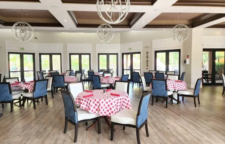 The amenities center with spacious dining area featuring multiple sets of French doors, and coffered ceilings.