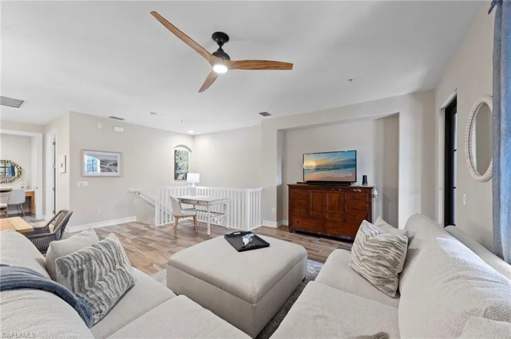 Open-concept living space featuring wood-finish flooring, a modern ceiling fan, and a built-in media niche. NEW TILE FLOOR (2018)
