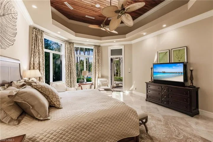 Bedroom featuring wood ceiling, ceiling fan, a tray ceiling, ornamental molding, and access to outside