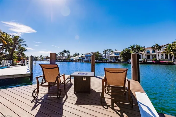 View of dock featuring a fire pit and a water view