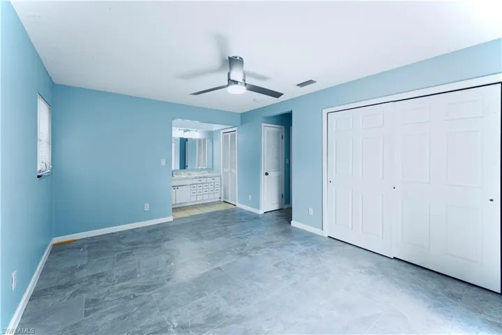 Unfurnished bedroom with a ceiling fan and ensuite bathroom