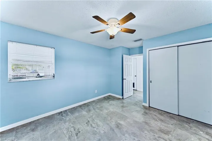Unfurnished bedroom with a ceiling fan, a textured ceiling, and a closet