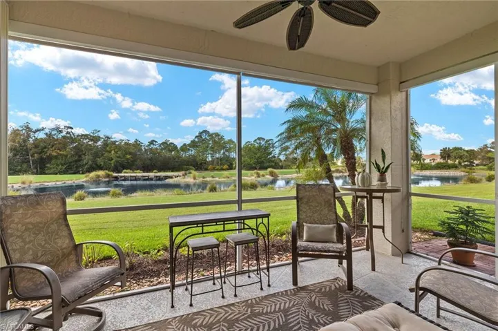 Sunroom / solarium featuring ceiling fan and a water view