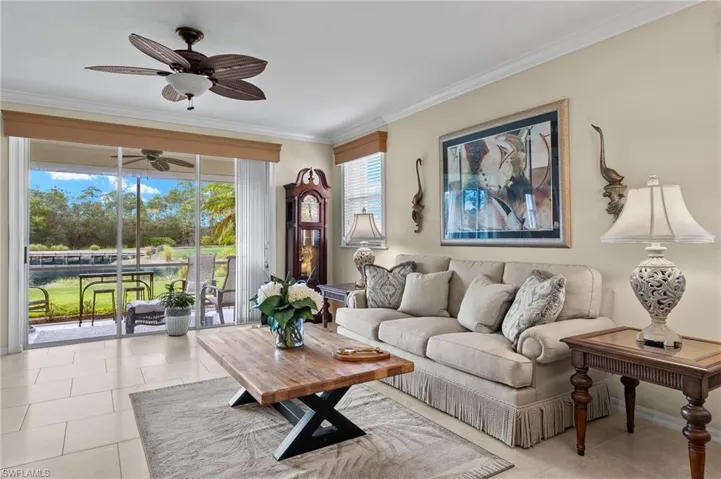 Tiled living room with ceiling fan, crown molding, and plenty of natural light