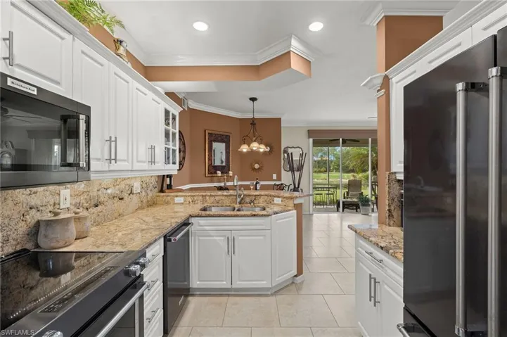 Kitchen with kitchen peninsula, appliances with stainless steel finishes, and white cabinets