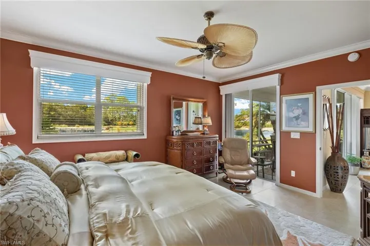 Tiled bedroom featuring ornamental molding, access to outside, multiple windows, and ceiling fan