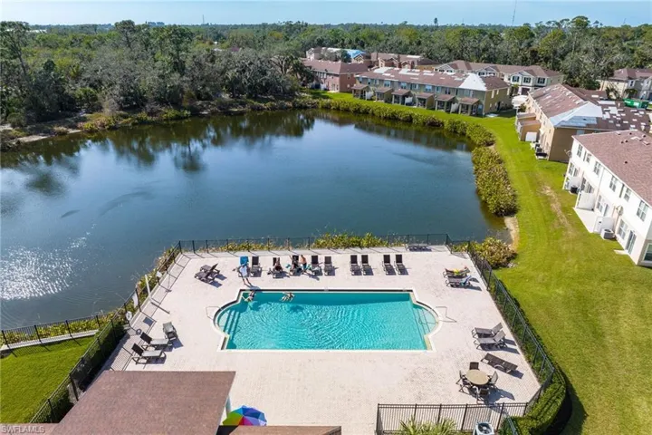 Drone / aerial view of a pool area and a large body of water