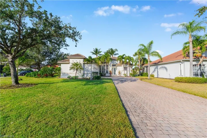 Mediterranean / spanish home featuring stucco siding, decorative driveway, and a front yard