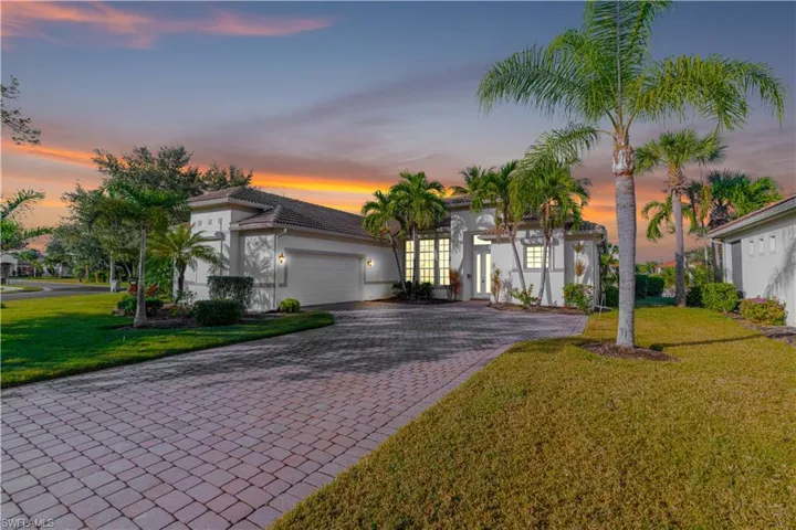 Mediterranean / spanish-style house with a lawn, a garage, decorative driveway, stucco siding, and a tiled roof