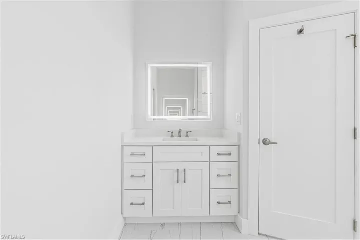 Bathroom with light marble finish floors and vanity