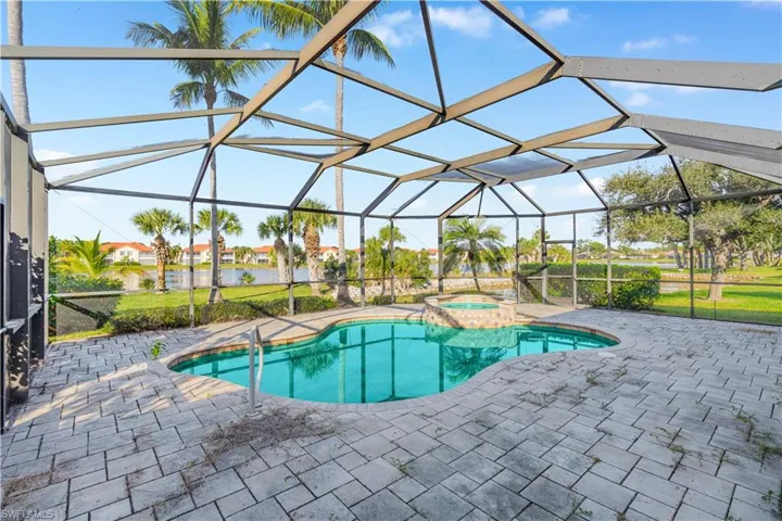 View of pool featuring a sunroom, a patio, glass enclosure, and a pool with connected hot tub