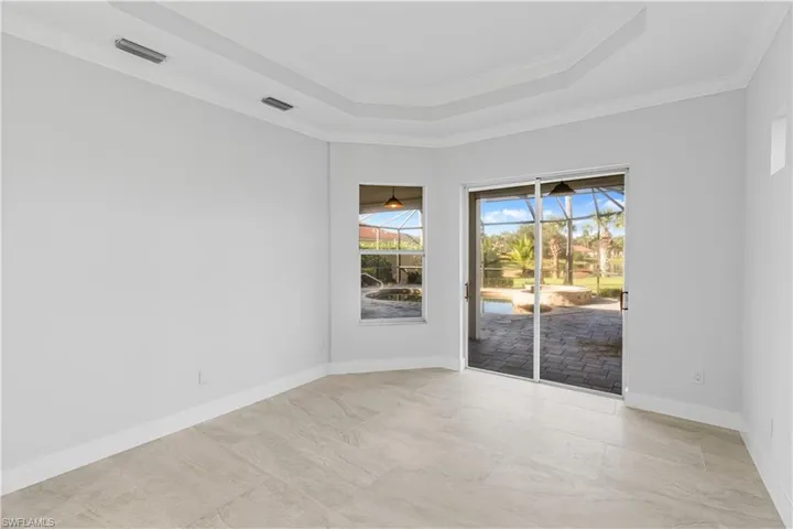 Unfurnished room with a sunroom, ornamental molding, and a raised ceiling