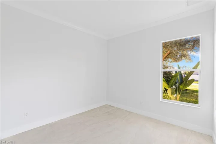 Empty room featuring baseboards and crown molding