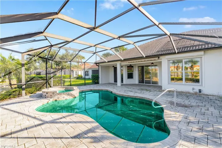 View of pool with a patio area, a sunroom, glass enclosure, and a pool with connected hot tub