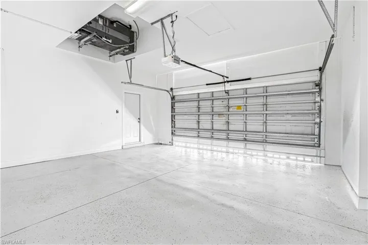 Garage featuring a garage door opener and baseboards