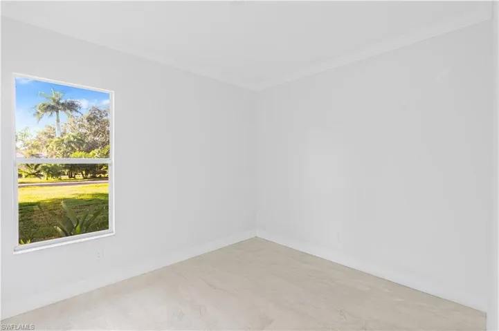 Empty room featuring crown molding and wood finished floors