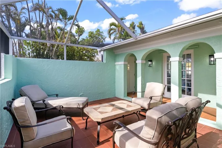 View of the courtyard looking towards the guest quarters with double french door and a covered walkway to the main home.