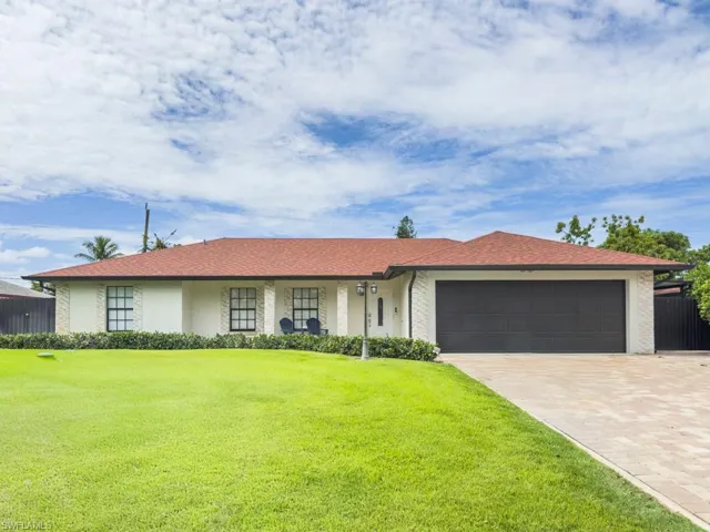 View of front of home featuring an attached garage, driveway, and stucco siding