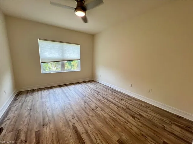 Empty room featuring Luxury vinyl plank / wood-style flooring and ceiling fan