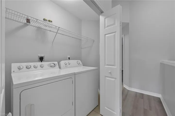 Laundry room featuring washing machine and clothes dryer and light wood-type flooring