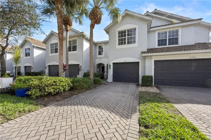 View of front of property featuring stucco siding, a garage, and decorative driveway