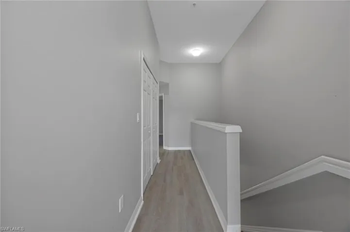 Corridor featuring an upstairs landing and light wood-style floors