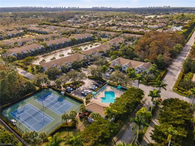 Aerial view of property and surrounding area featuring a large body of water and a pool area