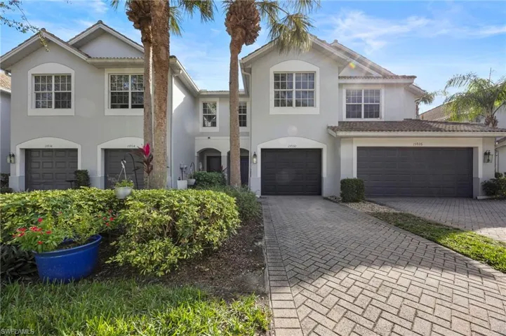 Traditional-style home featuring stucco siding, decorative driveway, and a garage