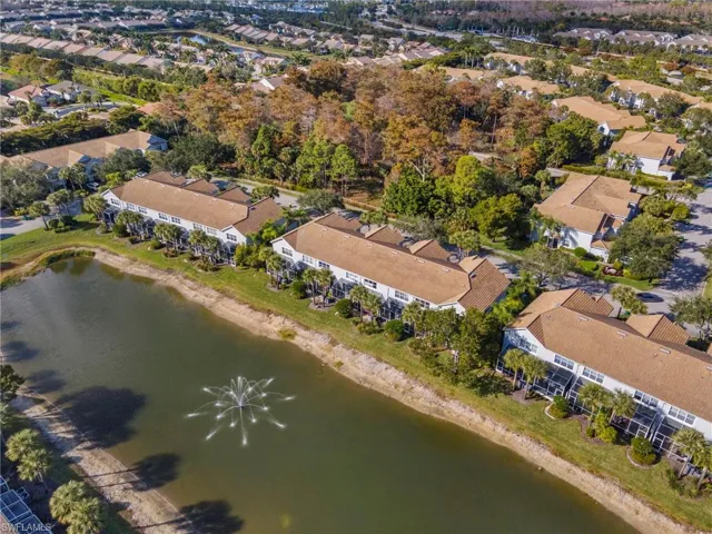 Aerial view of property and surrounding area featuring a large body of water and nearby suburban area
