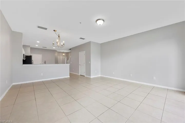 Unfurnished living room with a chandelier, recessed lighting, and light tile patterned flooring