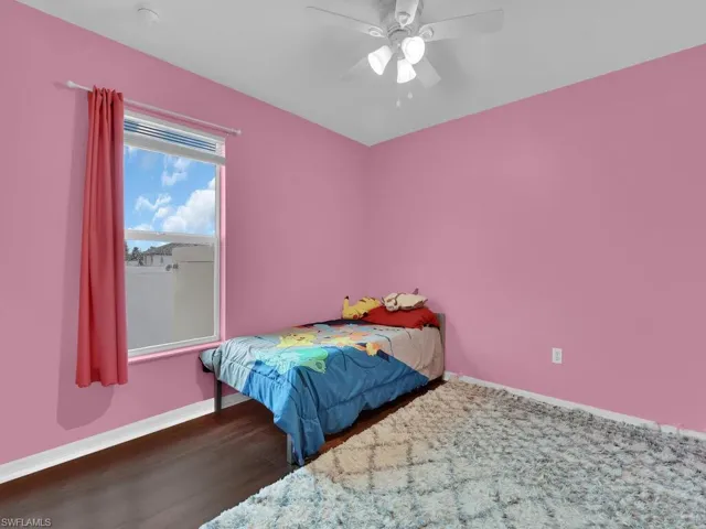 Bedroom with dark wood-type flooring and ceiling fan