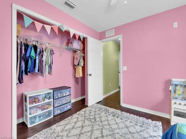 Bedroom with a closet, ceiling fan, and dark wood-type flooring