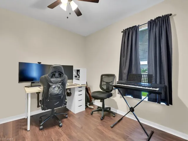 Office area with wood-type flooring and ceiling fan