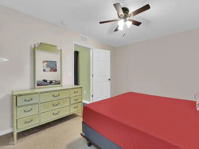 Carpeted bedroom featuring ceiling fan