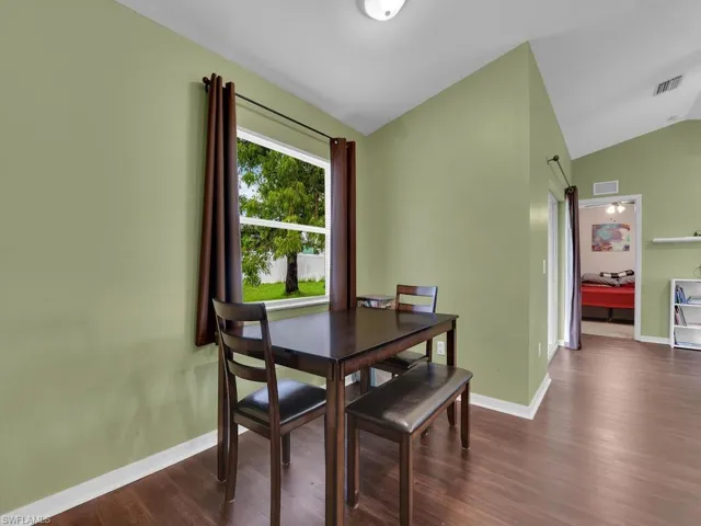 Dining room featuring dark hardwood / wood-style floors and lofted ceiling