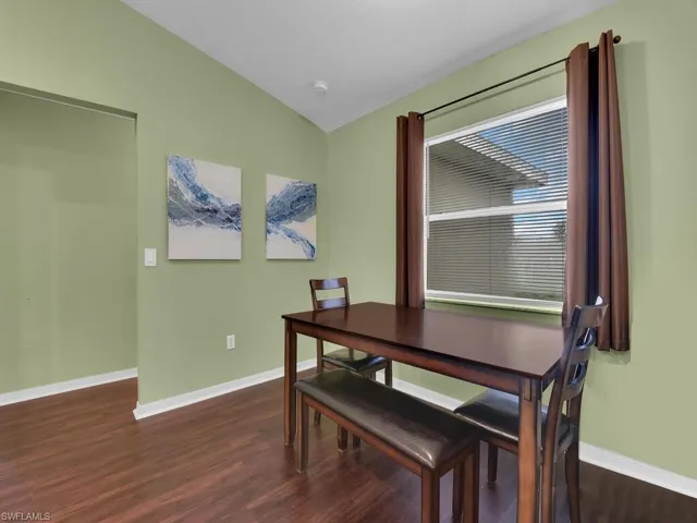 Dining space featuring dark wood-type flooring and lofted ceiling
