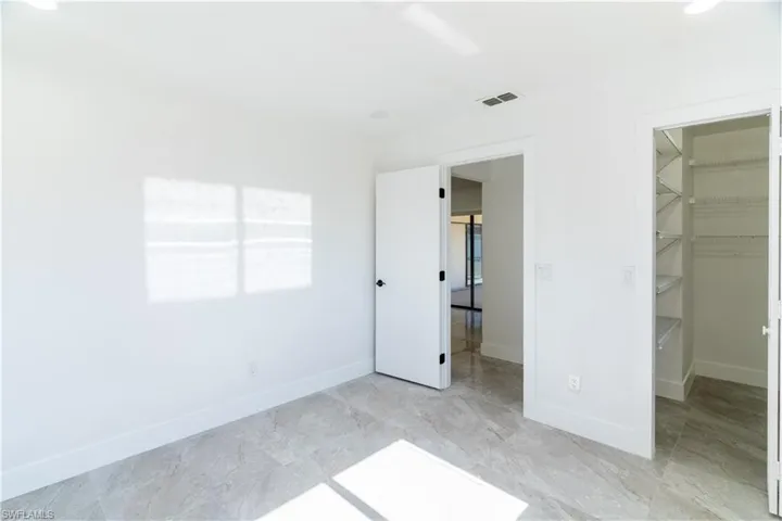 Unfurnished bedroom featuring a walk in closet and recessed lighting