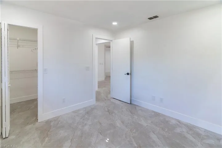 Unfurnished bedroom with a spacious closet and recessed lighting