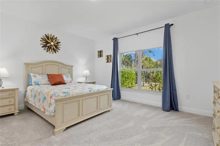 Bedroom featuring light carpet and baseboards