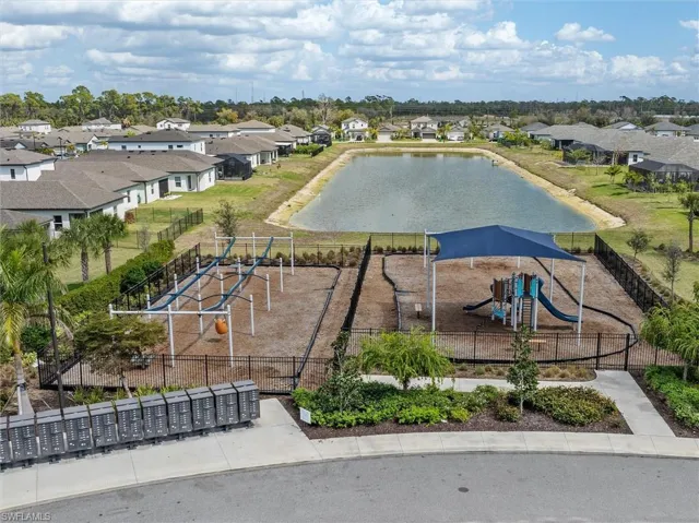 Aerial perspective of suburban area featuring a recreational park and a large body of water