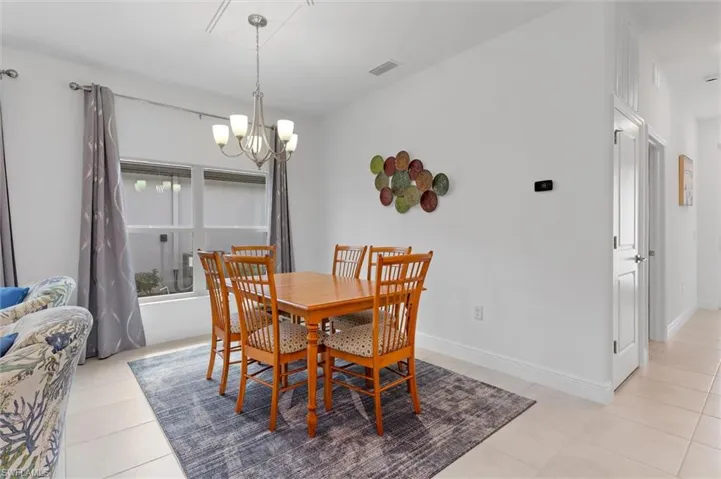 Dining area featuring a chandelier and light tile patterned flooring