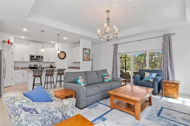 Living room featuring a raised ceiling and suspended lighting