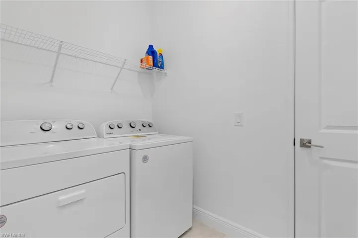 Laundry room with separate washer and dryer and baseboards